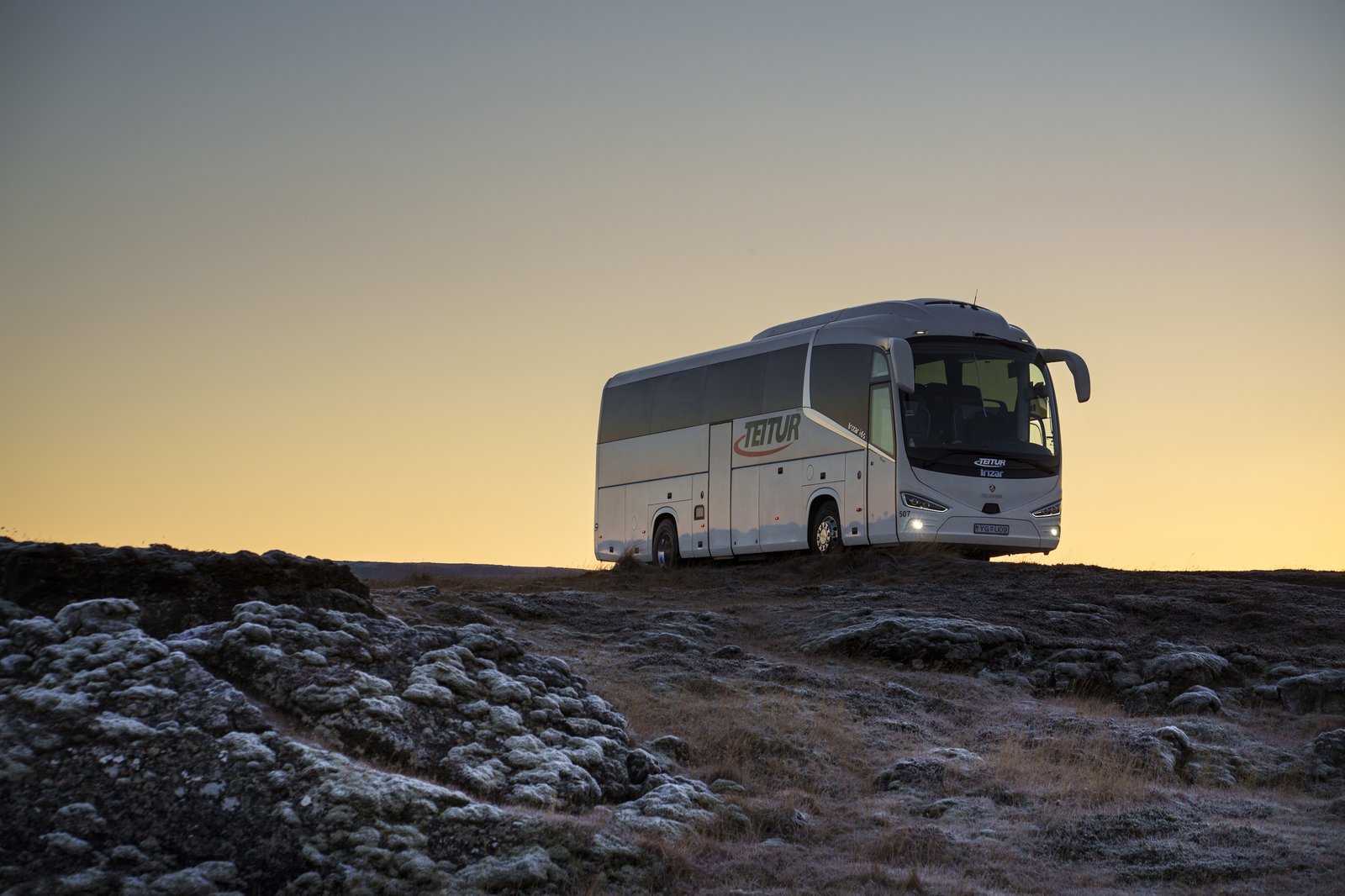 Teitur coach at sunset on lava rock