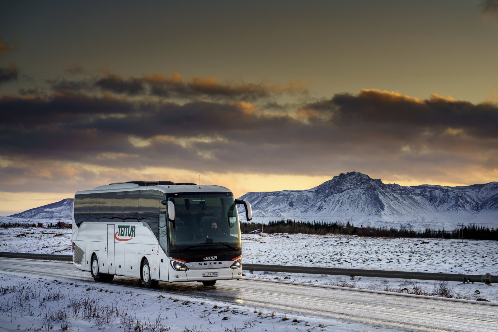 Teitur coach on winter road at sunset